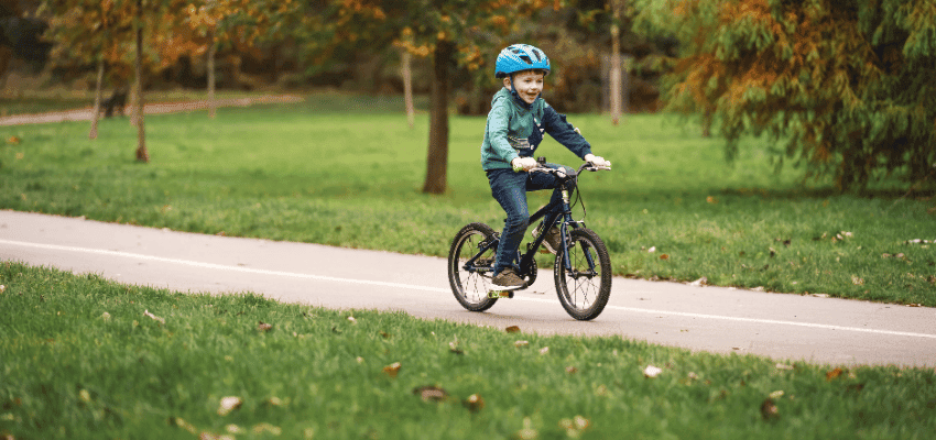 A child riding a bike along a park path with autumn trees in the background Purpl discounts shopping discounts for disabled people mobility discounts and offers accessibility discounts UK savings for people with long term health conditions cost of living help for disabled people