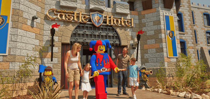 Family outside LEGOLAND® Windsor Castle Hotel entrance, Purpl discounts for disabilities and long term health conditions, disabled travel discounts UK.