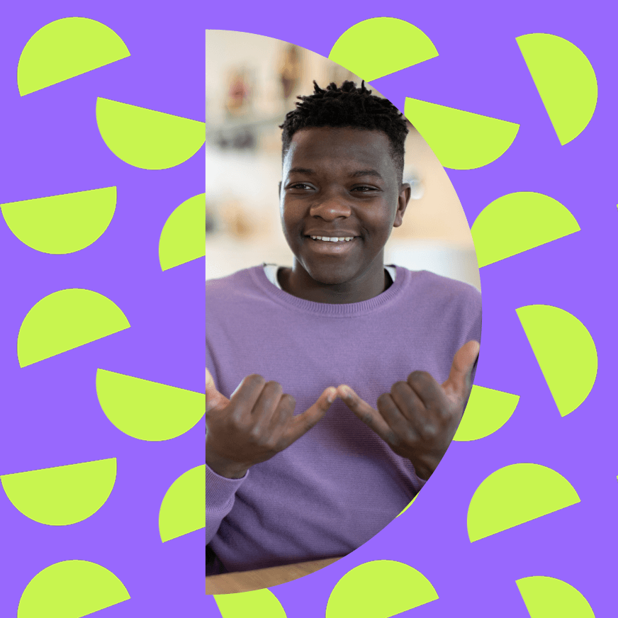 A smiling young man wearing a light purple sweater gestures with both hands, forming a "W" shape. The photo is framed in an oval shape against a colorful background with a purple base and green semi-circles arranged in a pattern.