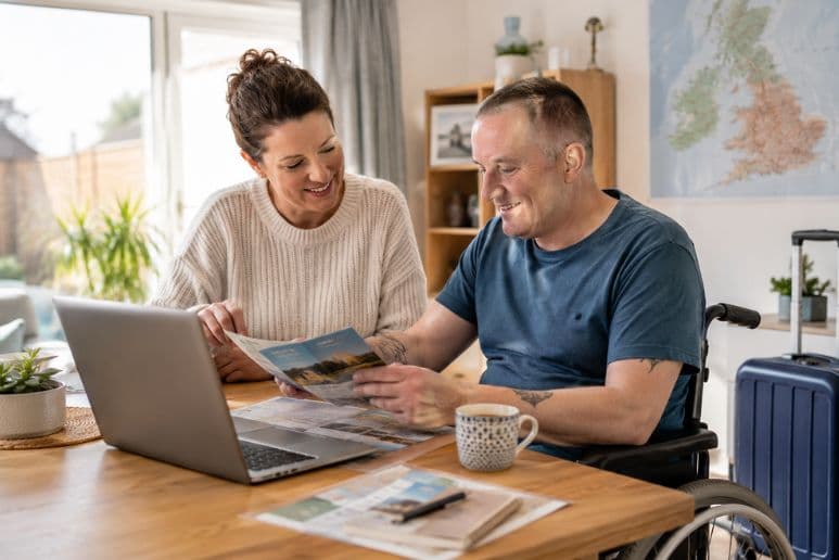 A disabled person planning an accessible holiday at home with travel notes, disability support and Purpl discounts for people with disabilities and long-term health conditions.
