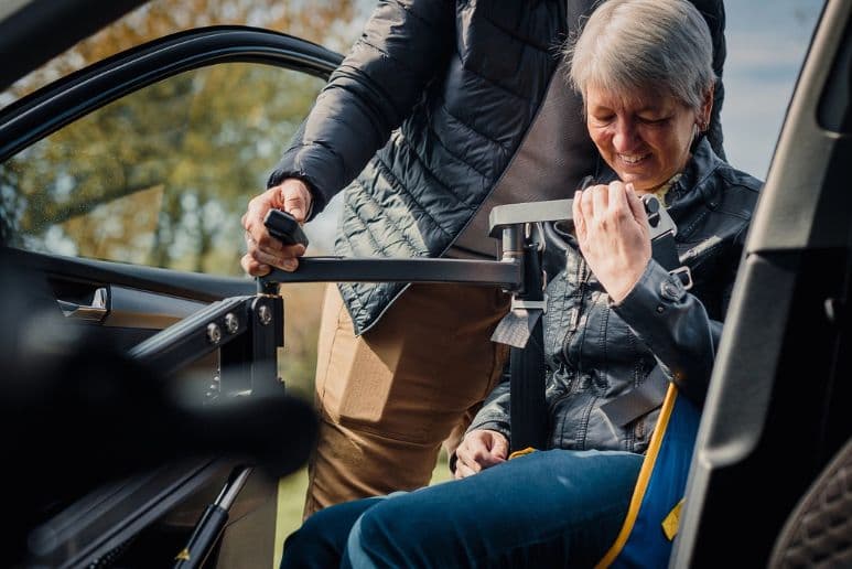 Disabled driver looking at an adapted vehicle with a mobility specialist, showing private adapted car ownership options after Motability.
