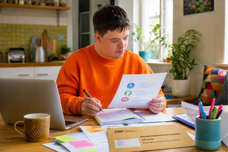 Disabled person reviewing PIP paperwork at home after the 2026 Timms Review